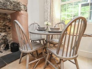 a dining room table with four chairs around it at Tryfan Cottage in Caernarfon