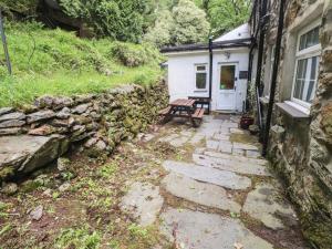 a house with a bench next to a building at Tryfan Cottage in Caernarfon