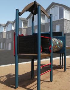 un parque infantil frente a un edificio en Seabird Apartment, en Portstewart