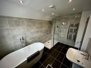 a bathroom with a bath tub and a sink at The Stag Rooms in Stratford-upon-Avon +78 photos