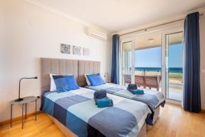 a bedroom with a bed with a view of the ocean at 426 Casa Onda Mirabaia in Albardeira +33 photos