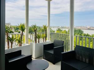 a balcony with chairs and a view of the water at Exceptional panoramic view in Bordeaux