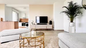 a living room with a couch and a glass table at Exceptional panoramic view in Bordeaux