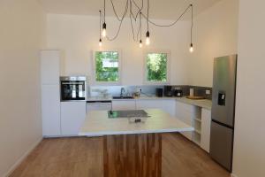 eine Küche mit weißen Schränken und einer Arbeitsplatte in der Unterkunft La terrasse du Colombier in Lantenay