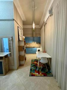 a room with a table and a kitchen with blue cabinets at Boomerang Apartments in Odesa
