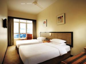 a hotel room with two beds and a window at Resorts World Genting - First World Hotel in Genting Highlands