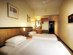 a hotel room with two beds and a television at Resorts World Genting - First World Hotel in Genting Highlands