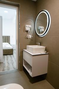 a bathroom with a sink and a mirror at Tepelena Center Hotel in Tepelenë +123 photos