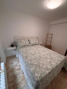 a bedroom with a bed with a comforter at GaliciaGuestHome Peregrina 18 in Pontevedra