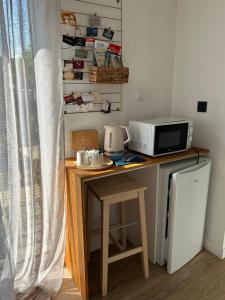 a kitchen with a counter with a microwave and a table at La Petite Mer in Riantec