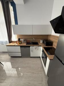 a small kitchen with a sink and a stove at F3 centre-ville, parking privé in Auxerre +8 photos