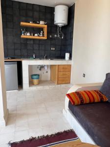 a kitchen with a couch and a counter in a room at SurfAppart Morocco in Tamraght Ouzdar