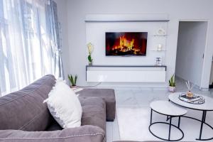 a living room with a couch and a fireplace at Gaborone City Center stay, ultrafast wifi & near CBD & Airport in Joverega
