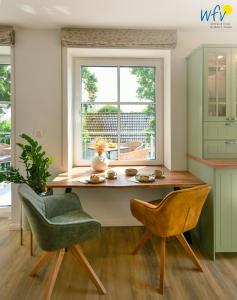 a kitchen with a table and chairs and a window at Haus Christine Ferienwohnung 4 in Langeoog