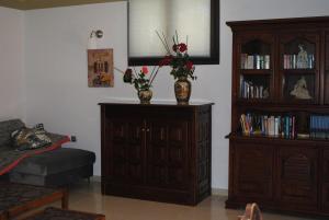 Un dormitorio con una cómoda y un jarrón con flores. en Stone House by the Sea, en Tavronitis 11 fotos más