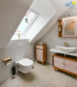 a bathroom with a sink and a toilet and a skylight at Haus Christine Ferienwohnung 4 in Langeoog