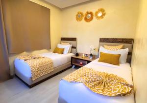 a hotel room with two beds with yellow and white at Villa Sable de Mirleft Luxury Apartment in Mirleft +37 photos
