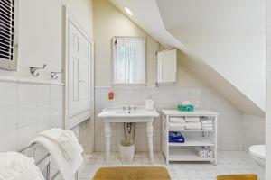 a white bathroom with a sink and a toilet at Point Radio Cottage in Gloucester