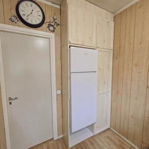 eine Küche mit einem Kühlschrank und einer Uhr an der Wand in der Unterkunft Bright Cozy Private Rooms 3min to Metro in Helsinki