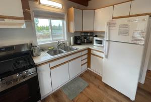 eine Küche mit einem weißen Kühlschrank und einer Spüle in der Unterkunft Peaceful Acres Cabin 4 - Get-N-Away in Soldotna