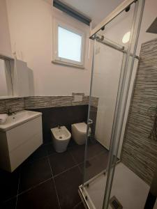 a bathroom with a toilet and a sink and a shower at Villa al Plemmirio Luxury in Plemmirio
