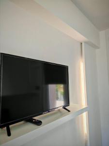 a large flat screen tv sitting on a shelf at Villa Plemmirio Reserve in Plemmirio