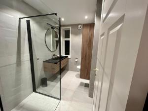 un bagno con doccia, lavandino e specchio di Historic House City Centre a Bergen Altre 11 foto