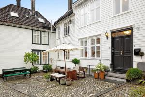 un patio con panchina e ombrellone di fronte a una casa di Historic House City Centre a Bergen