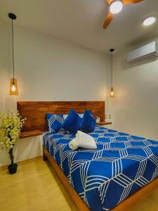 a bedroom with a blue and white bed with blue pillows at Casa Bonita PXM in Puerto Escondido +24 photos