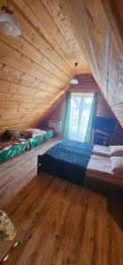 sypialnia na poddaszu z łóżkiem i oknem w obiekcie Maria Chyc wynajem pokoi gościnnych w Zakopanem +15 zdjęć