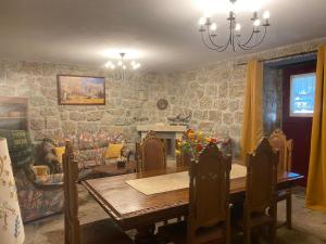 a dining room with a table and a fireplace at Casa Sequeira de São José - Gerês in Terras de Bouro