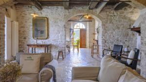 a living room with two couches in a stone wall at Checello 12 by Marche Holiday Villas in Cagli