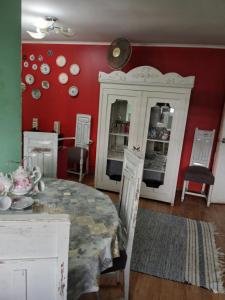 a dining room with white cabinets and a table at Cabaña con tinaja de hidromasaje in Valdivia