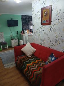 a living room with a red couch in a room at Cabaña con tinaja de hidromasaje in Valdivia