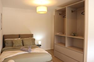 a small bedroom with a bed and shelves at Studio Flat Above MK Station in Milton Keynes