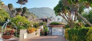 a house with a blue door in a garden at B&B Villa Anna Wunderbar in Casamicciola Terme