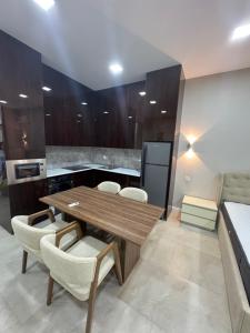 a kitchen with a wooden table and chairs at Sea breeze Park residens 2 in Baku