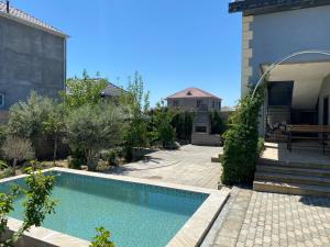 Una piscina en un patio con un edificio. en Home Turkan, en Türkan 1 foto más