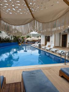 a large swimming pool with chairs and chandeliers at Vila Anna in Ksamil