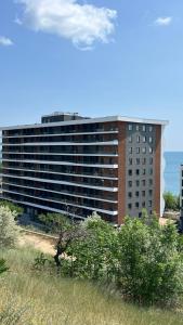 a large building in front of a grassy field at VEM Apartment Калипсо in Odesa