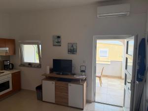 a kitchen with a door leading to a patio at Apartman Kraljević Vir 2 in Vir