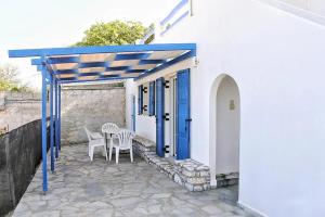a patio with a table and chairs and a blue door at Kalliopi's Aegean View in Episkopíon