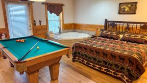 a bedroom with a pool table and a tub at A Painted Pony in Sevierville