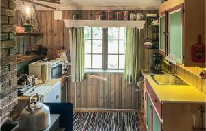 a small kitchen with a sink and a window at Cozy Home In Nissedal in Solli