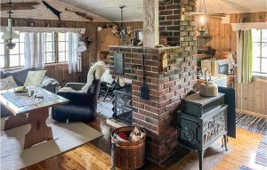 a living room with a brick fireplace with a stove at Cozy Home In Nissedal in Solli