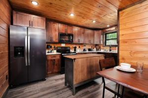 a kitchen with a stainless steel refrigerator and wooden cabinets at Saving Grace Where the Mountains Save the Day in Pigeon Forge