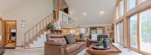 a living room with a couch and a staircase at Fireplace Fire Pit Covered Porch & Resort Access in Hedgesville +45 photos