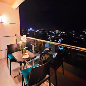 a room with a table and chairs and a view of a city at The ReLuxe Baguio Suite CityHub in Baguio
