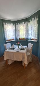 comedor con mesa, sillas y ventanas en Camping Gasthof Zirknitzer, en Großkirchheim