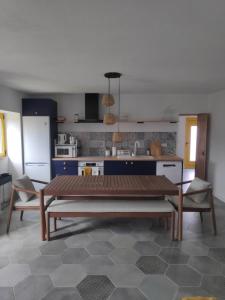 a kitchen with a table and chairs in a room at Casas de Campo de Vale de Junco in Envendos